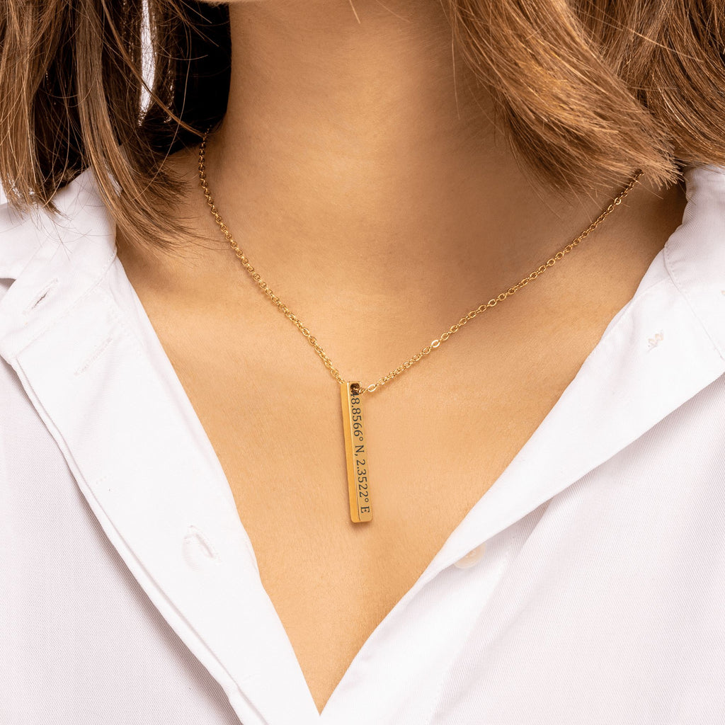 De gouden 3D-staafketting om de hals gedragen