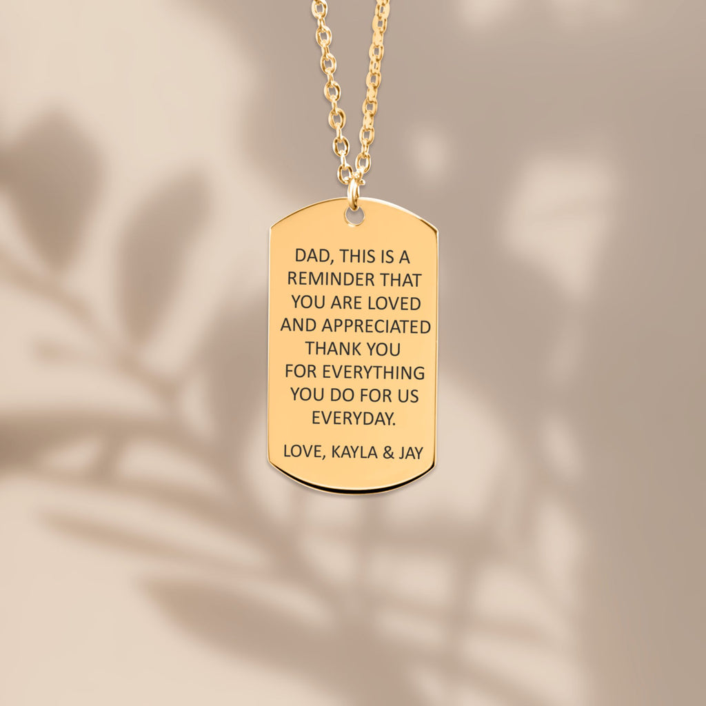 De gouden ketting met gegraveerd plaatje, hangend van dichtbij