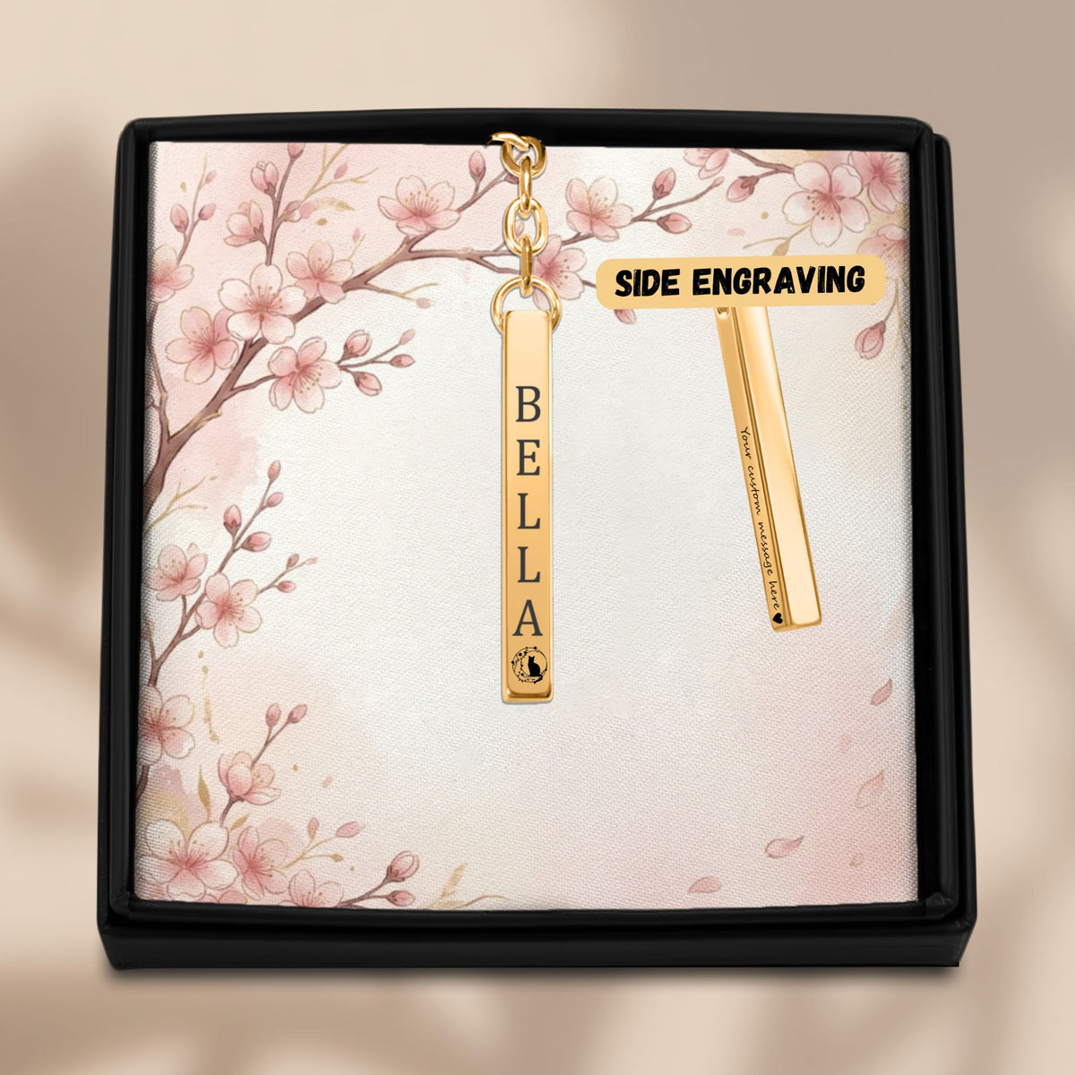 De gouden 3D-staafsleutelhanger in het geschenkdoosje, met de tweede zijde ernaast