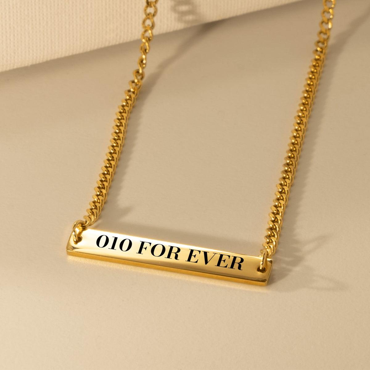 De gouden cuban link ketting met 010 FOR EVER gegraveerd, liggend van dichtbij