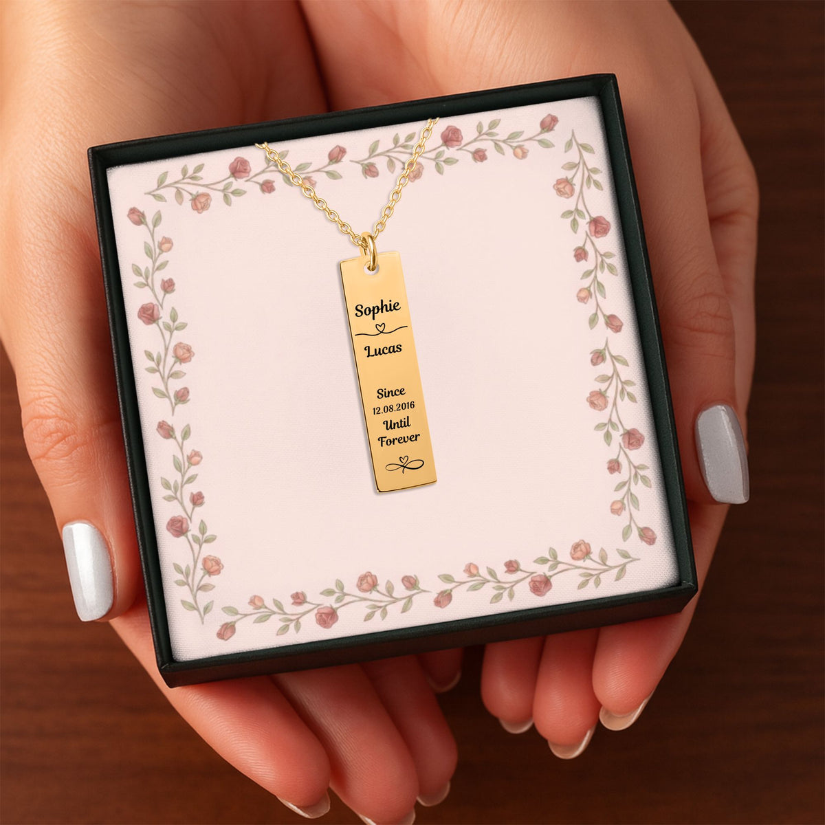 Het geschenkdoosje met de gouden staafketting, in twee handen