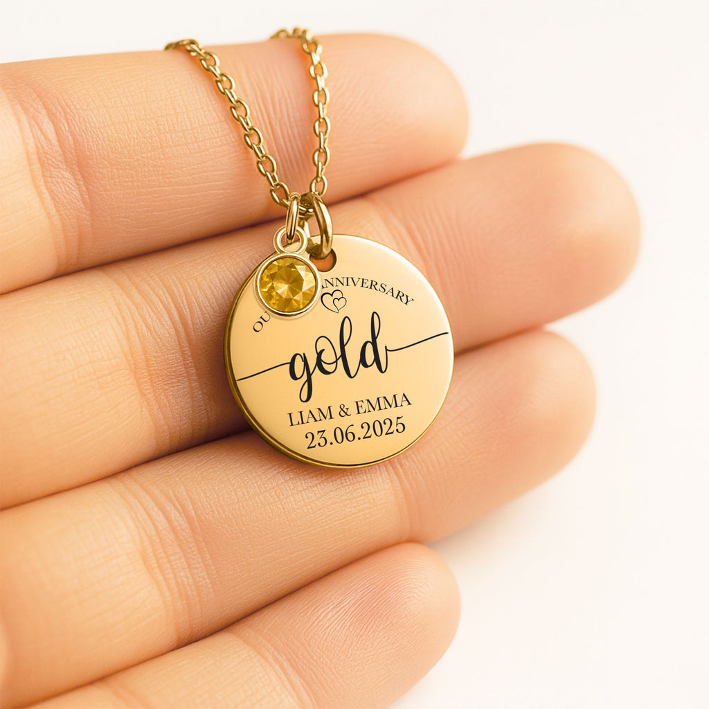 De gouden muntketting met geboortesteen in een handpalm
