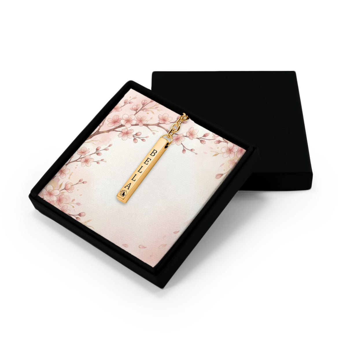 Het geschenkdoosje met de gouden 3D-staafsleutelhanger, met het deksel ernaast