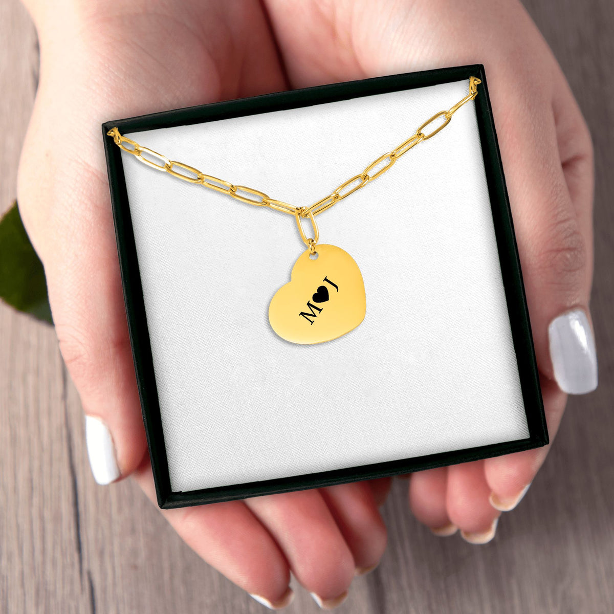 Het geschenkdoosje met de gouden paperclipketting, in een hand