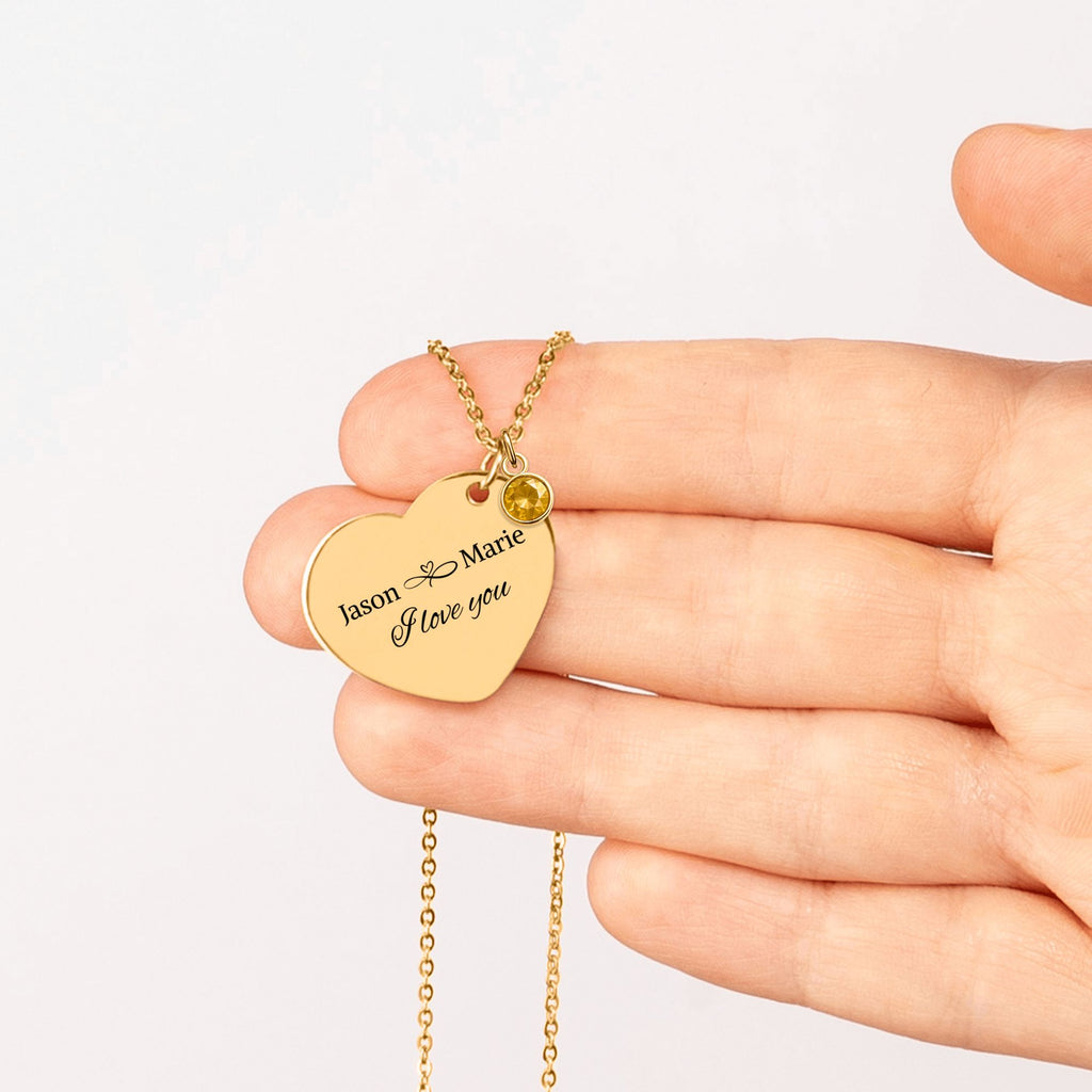 De gouden hartketting met geboortesteen in een handpalm