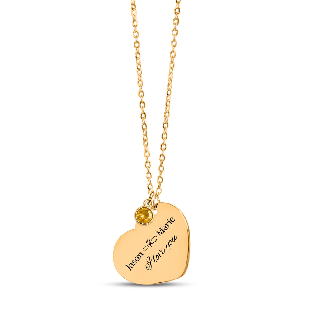 De gouden hartketting met geboortesteen, in de vingers gehouden