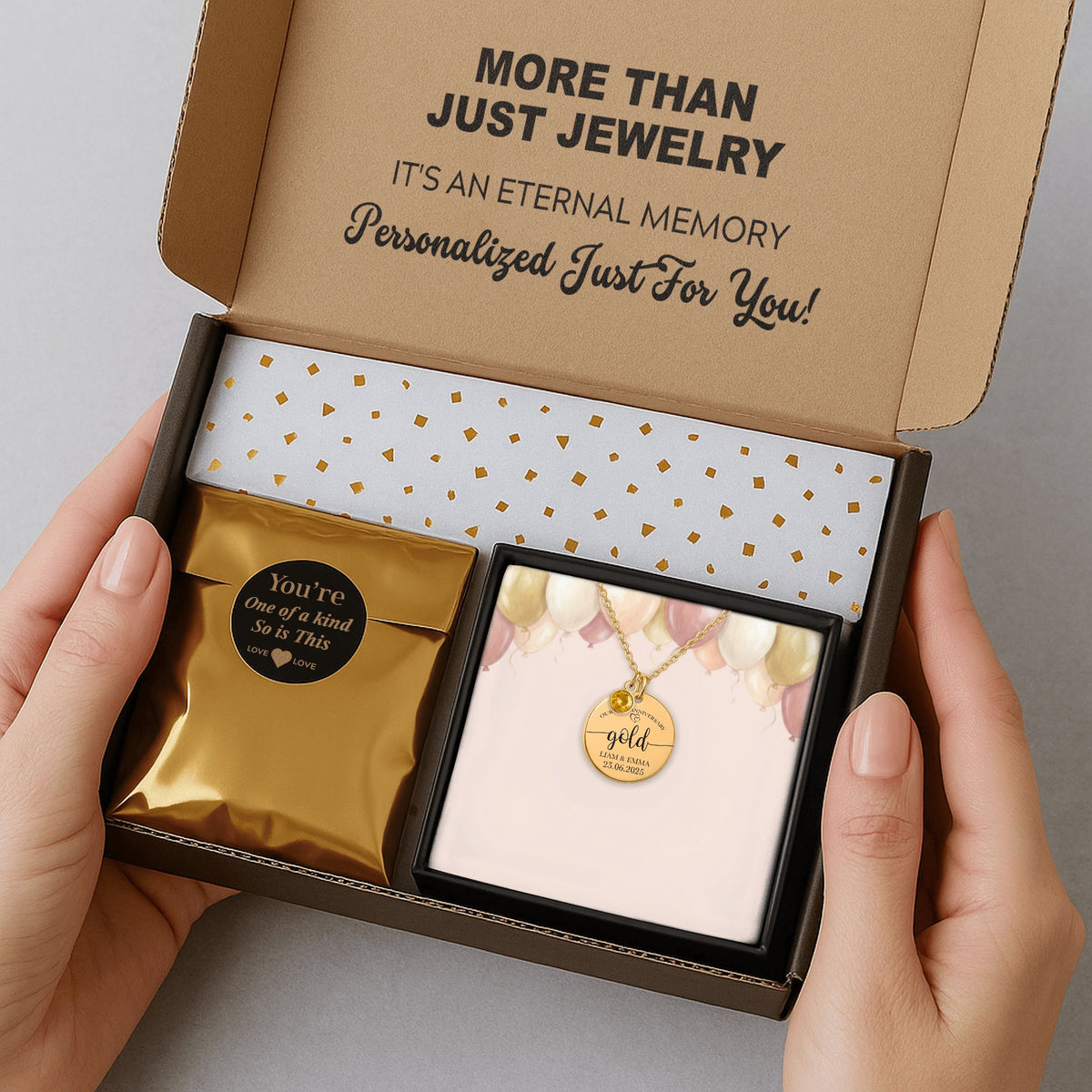 De gouden muntketting met geboortesteen in de verzenddoos met kaartje