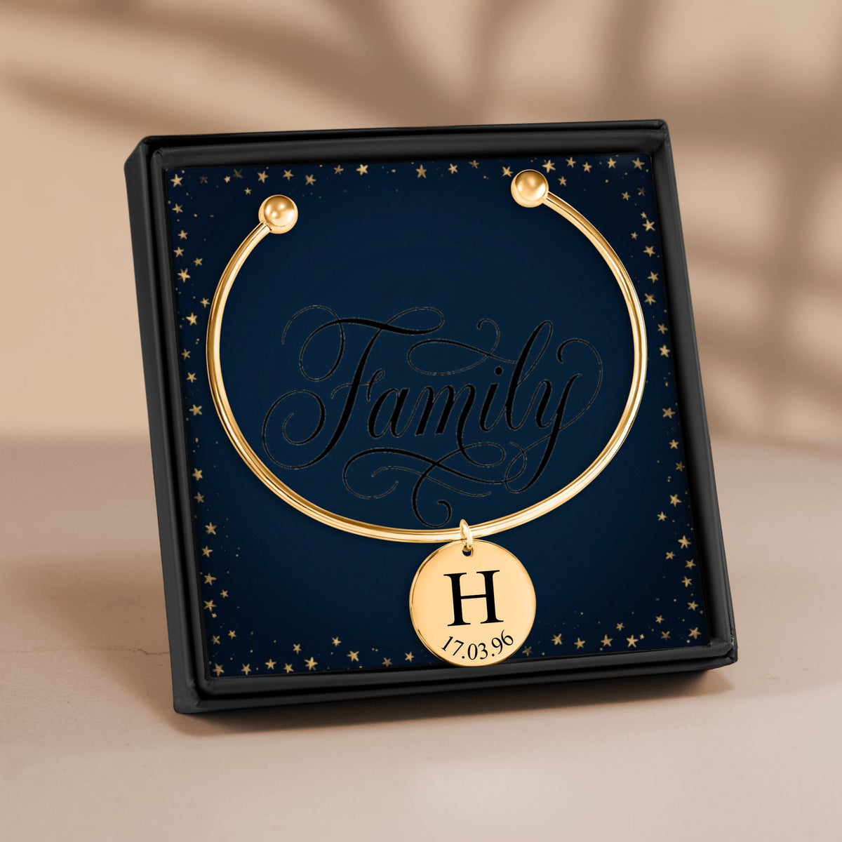 De bangle met gegraveerde hanger in goud, in een geschenkdoosje