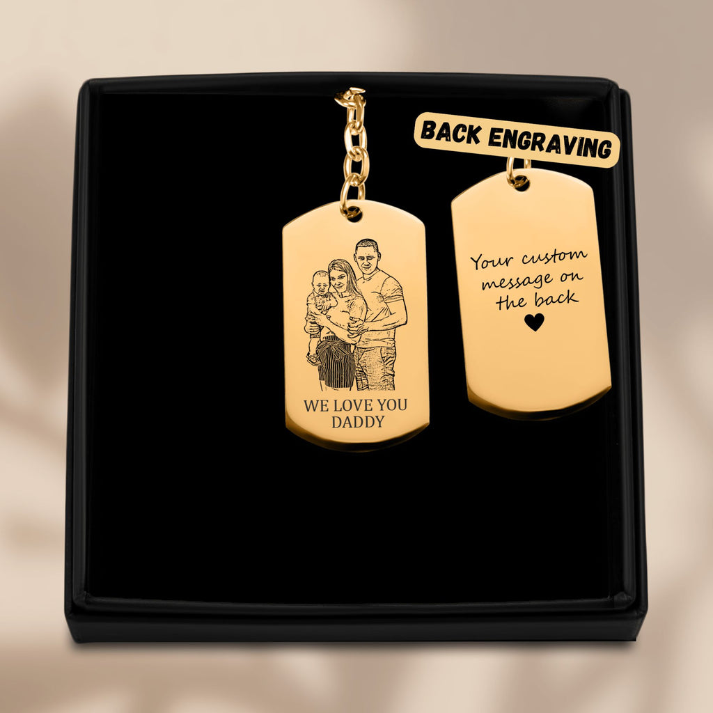 De gouden sleutelhanger met gegraveerd plaatje in het geschenkdoosje, met de achterkant ernaast