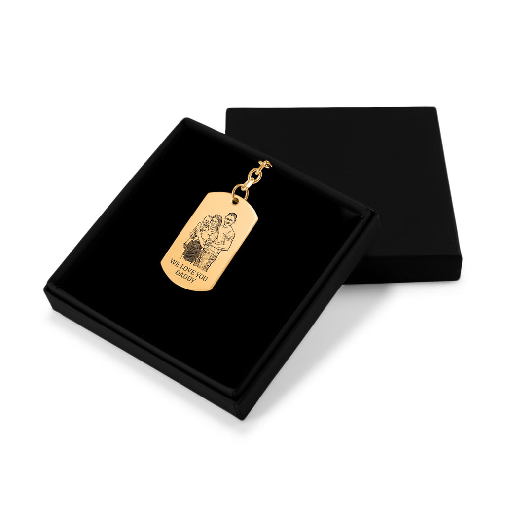 Het geschenkdoosje met de gouden sleutelhanger met gegraveerd plaatje, met het deksel ernaast