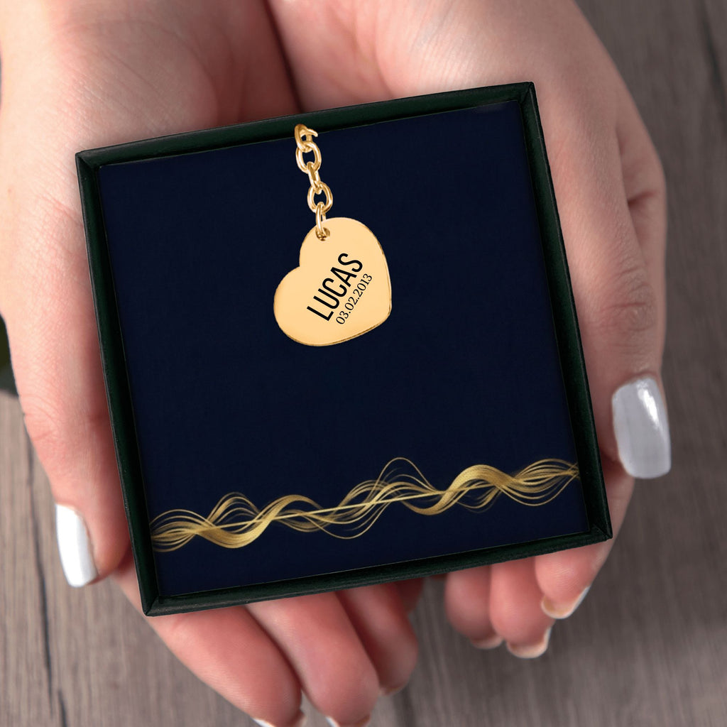 Het geschenkdoosje met de gouden hartvormige sleutelhanger, in twee handen
