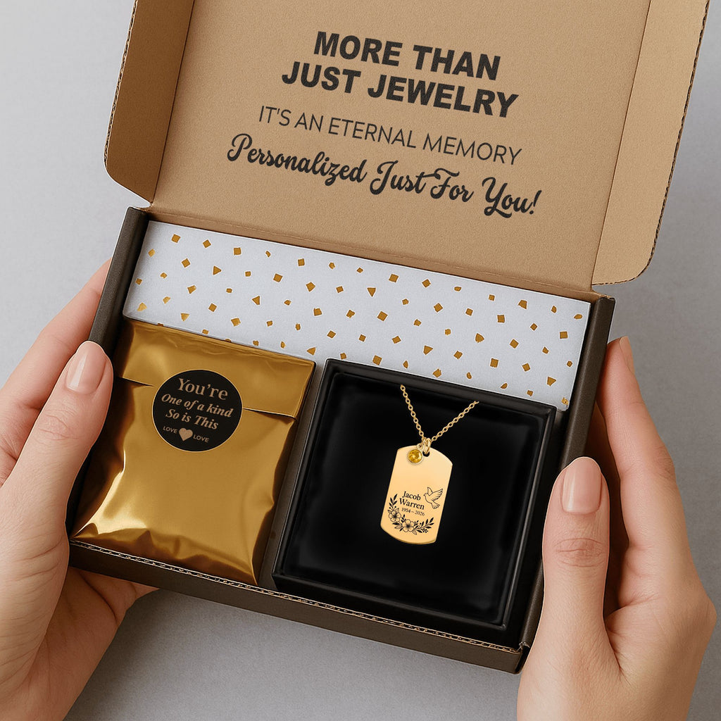De gouden ketting met gegraveerd plaatje met geboortesteen in de verzenddoos met kaartje