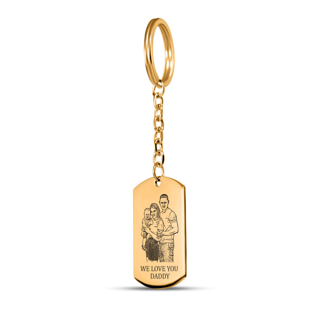 De gouden sleutelhanger met gegraveerd plaatje met ring en ketting, tegen wit
