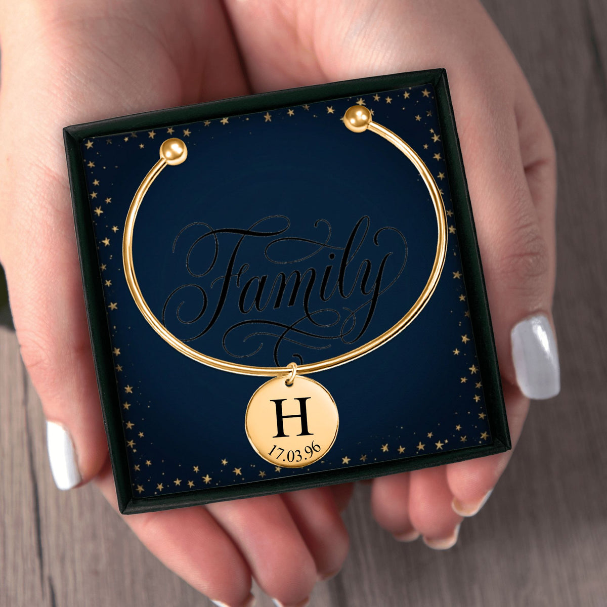 Het geschenkdoosje met de gouden bangle, in twee handen