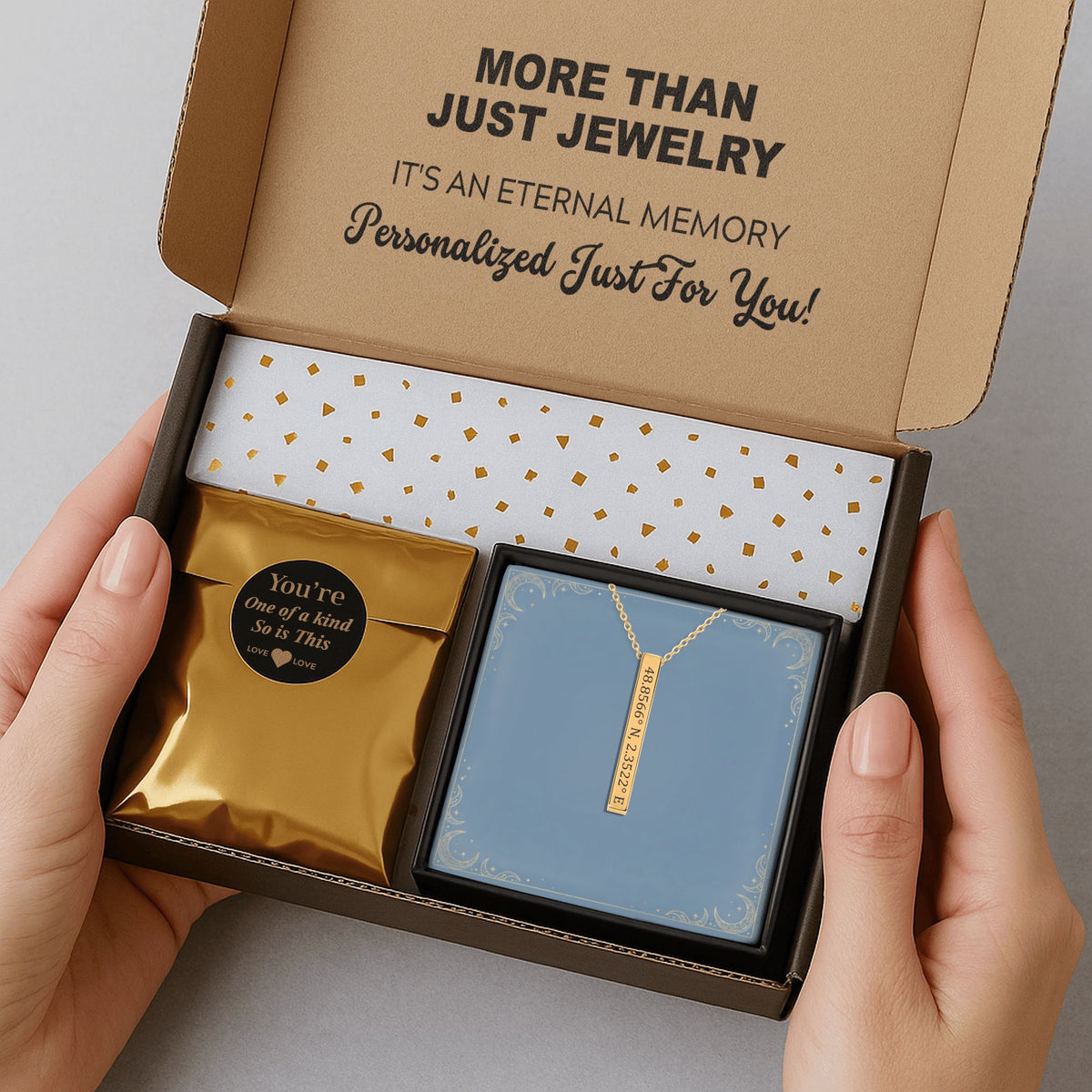 De gouden 3D-staafketting in de verzenddoos met kaartje