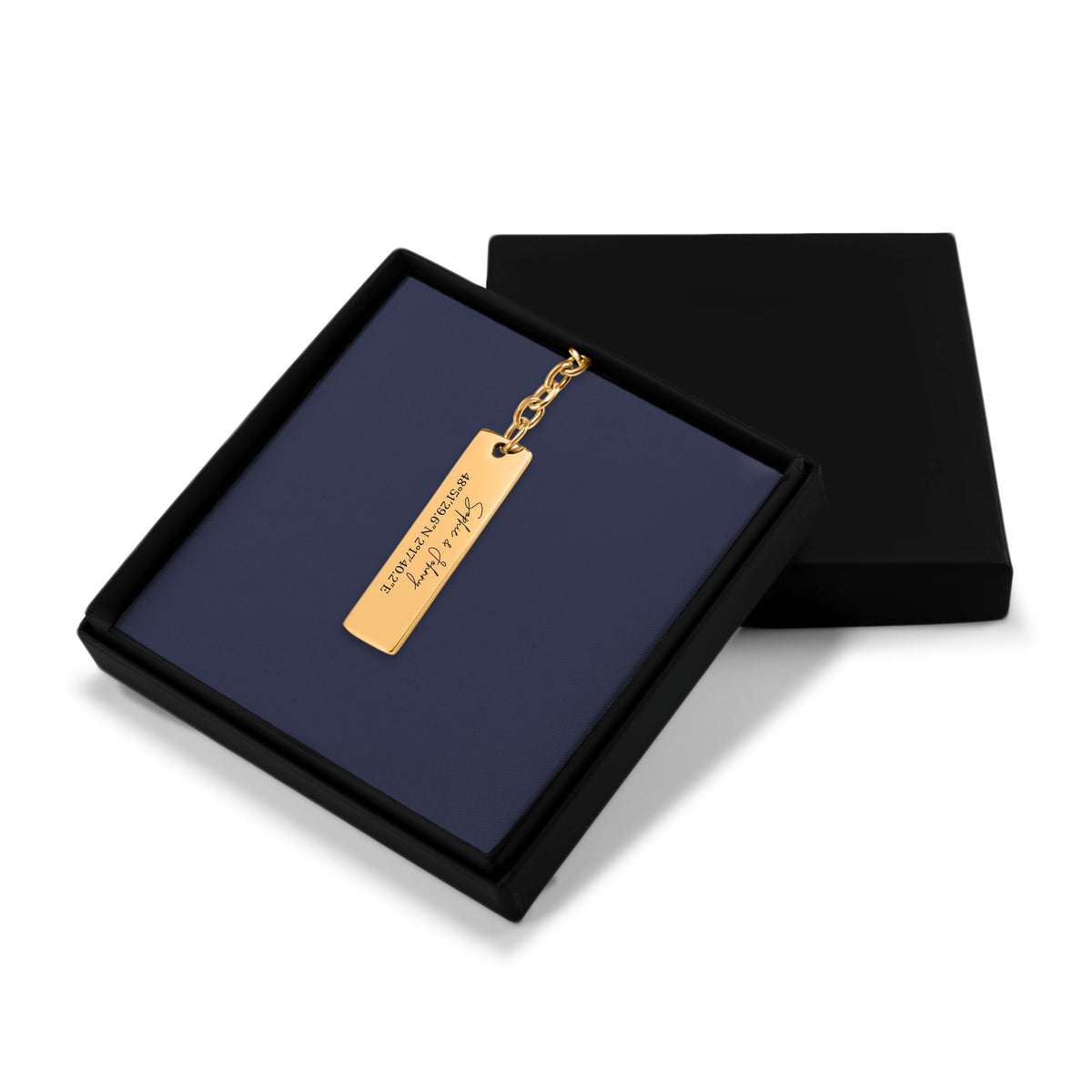 Het geschenkdoosje met de gouden staafsleutelhanger, met het deksel ernaast