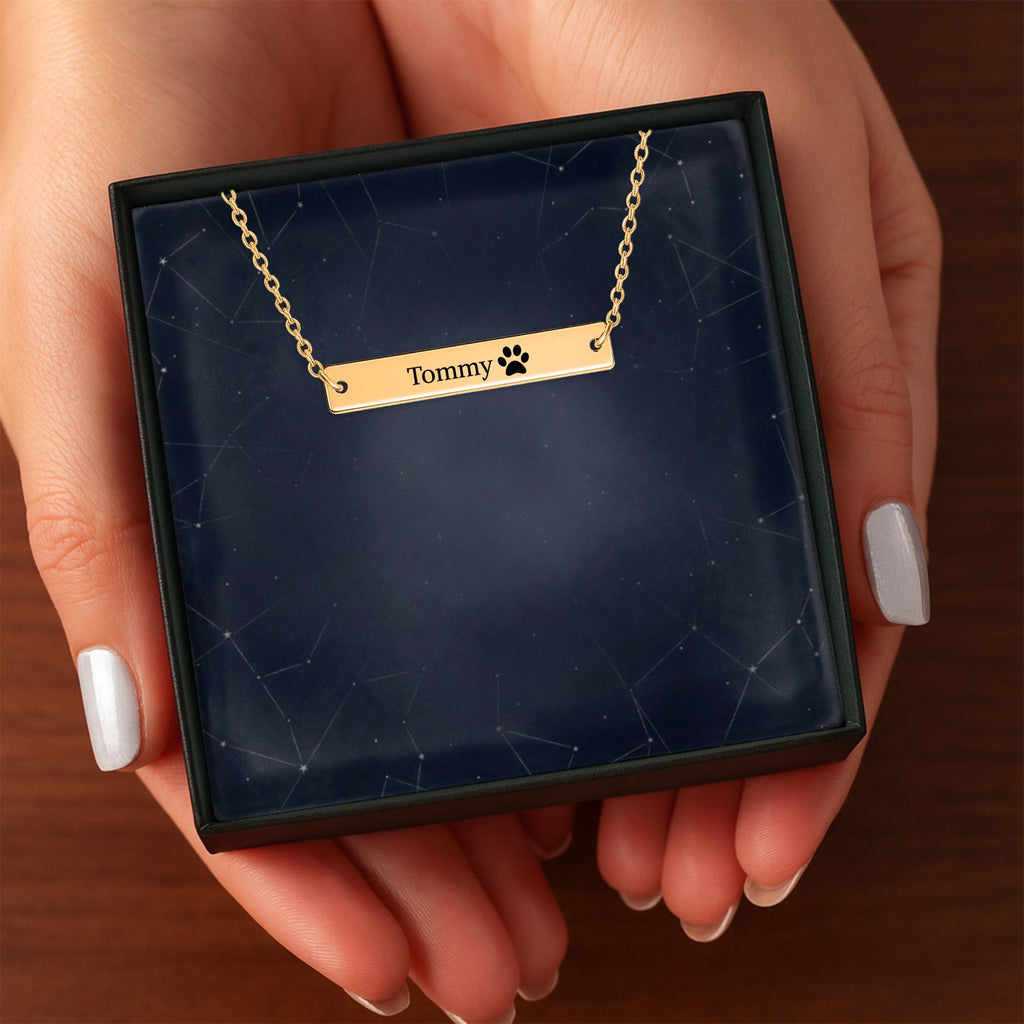 Het geschenkdoosje met de gouden horizontale staafketting, in twee handen