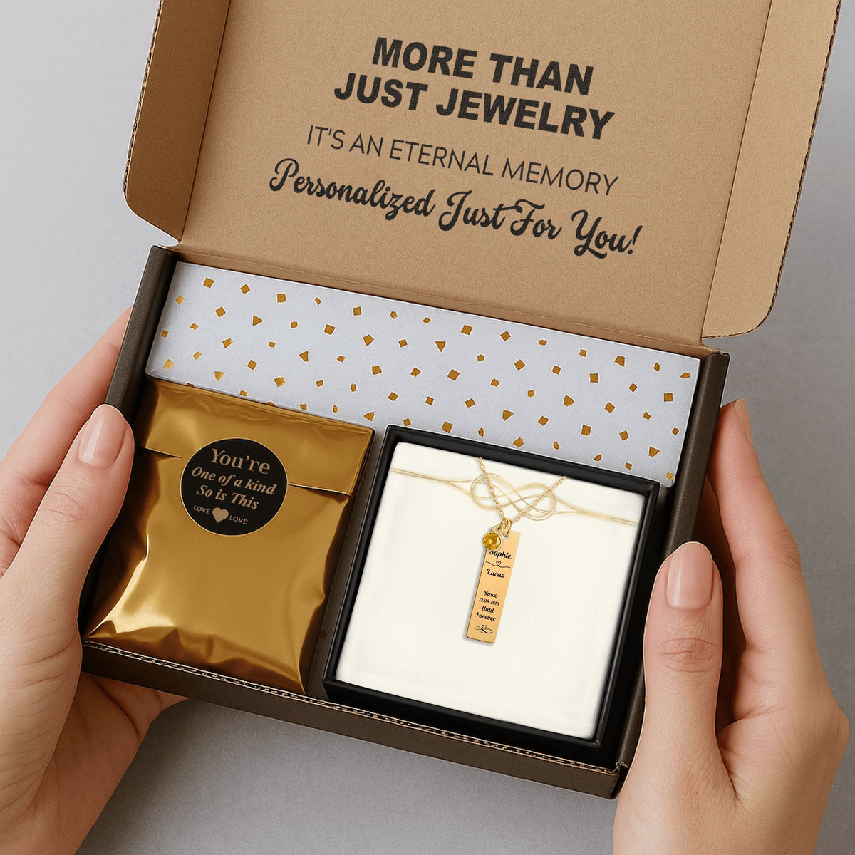 De gouden staafketting met geboortesteen in de verzenddoos met kaartje