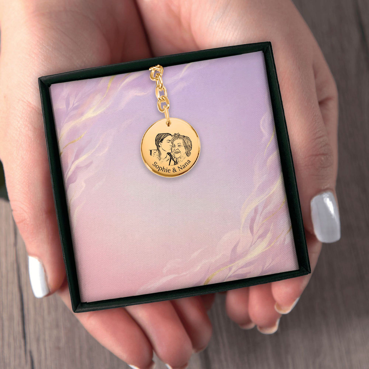 Het geschenkdoosje met de gouden muntsleutelhanger, in twee handen