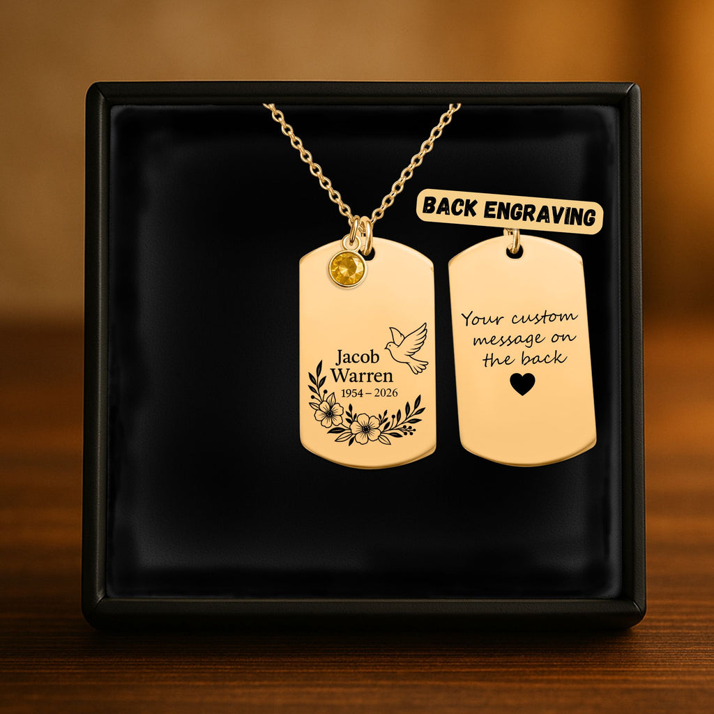 De gouden ketting met gegraveerd plaatje met geboortesteen in het geschenkdoosje, met de achterkant ernaast