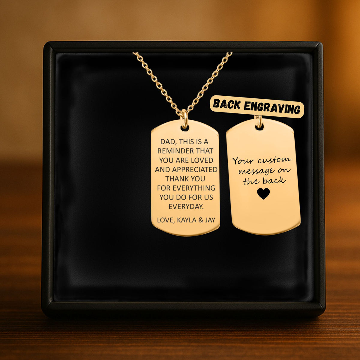 De gouden ketting met gegraveerd plaatje in het geschenkdoosje, met de achterkant ernaast
