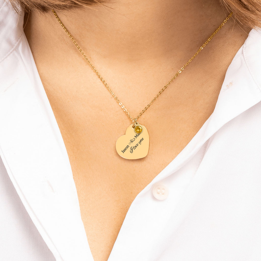 De gouden hartketting met geboortesteen om de hals gedragen