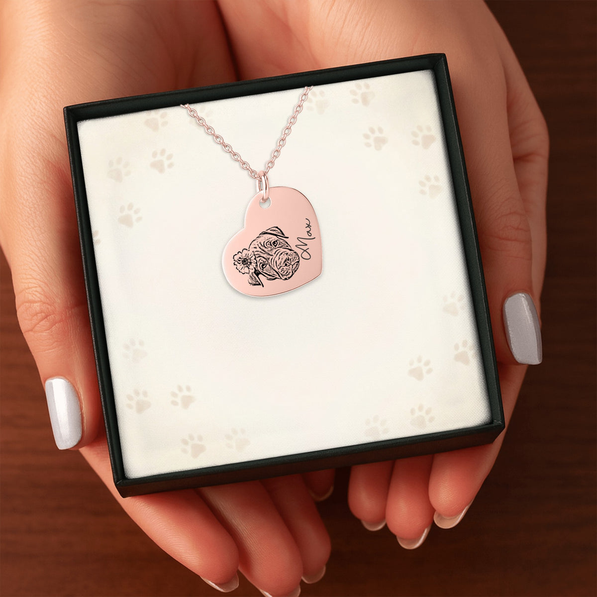 Het geschenkdoosje met de roségouden hartketting, in twee handen