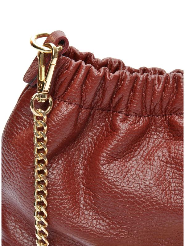 Close-up van het leer en het beslag van de donkerrode crossbodytas