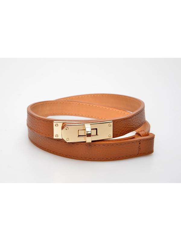 Close-up van het goudkleurige draaislot van de cognackleurige riem