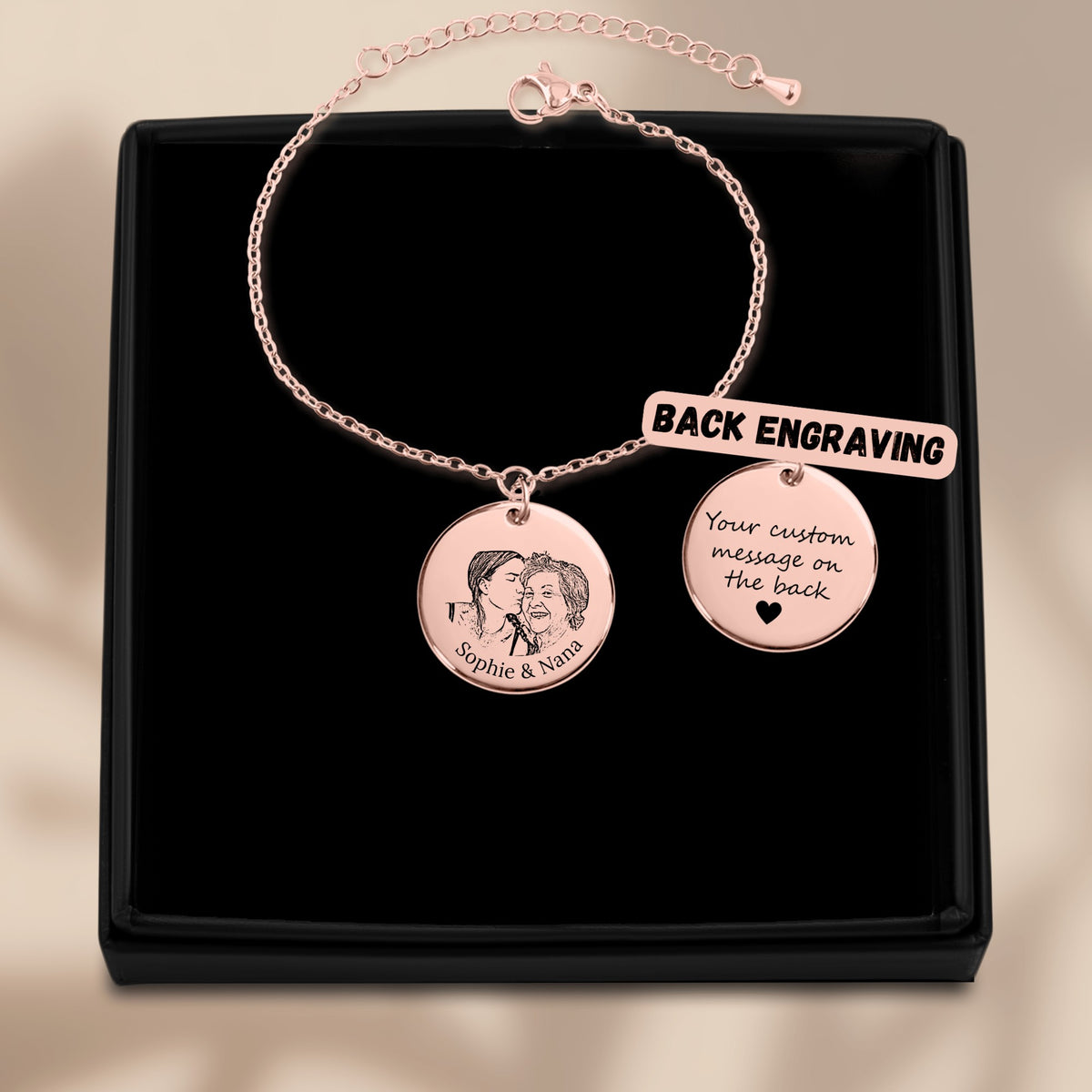 De muntarmband met gegraveerde munt in roségoud, in een geschenkdoosje, met de achterkant ernaast