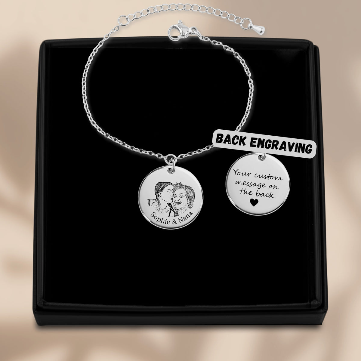 De muntarmband met gegraveerde munt in zilverkleur, in een geschenkdoosje, met de achterkant ernaast