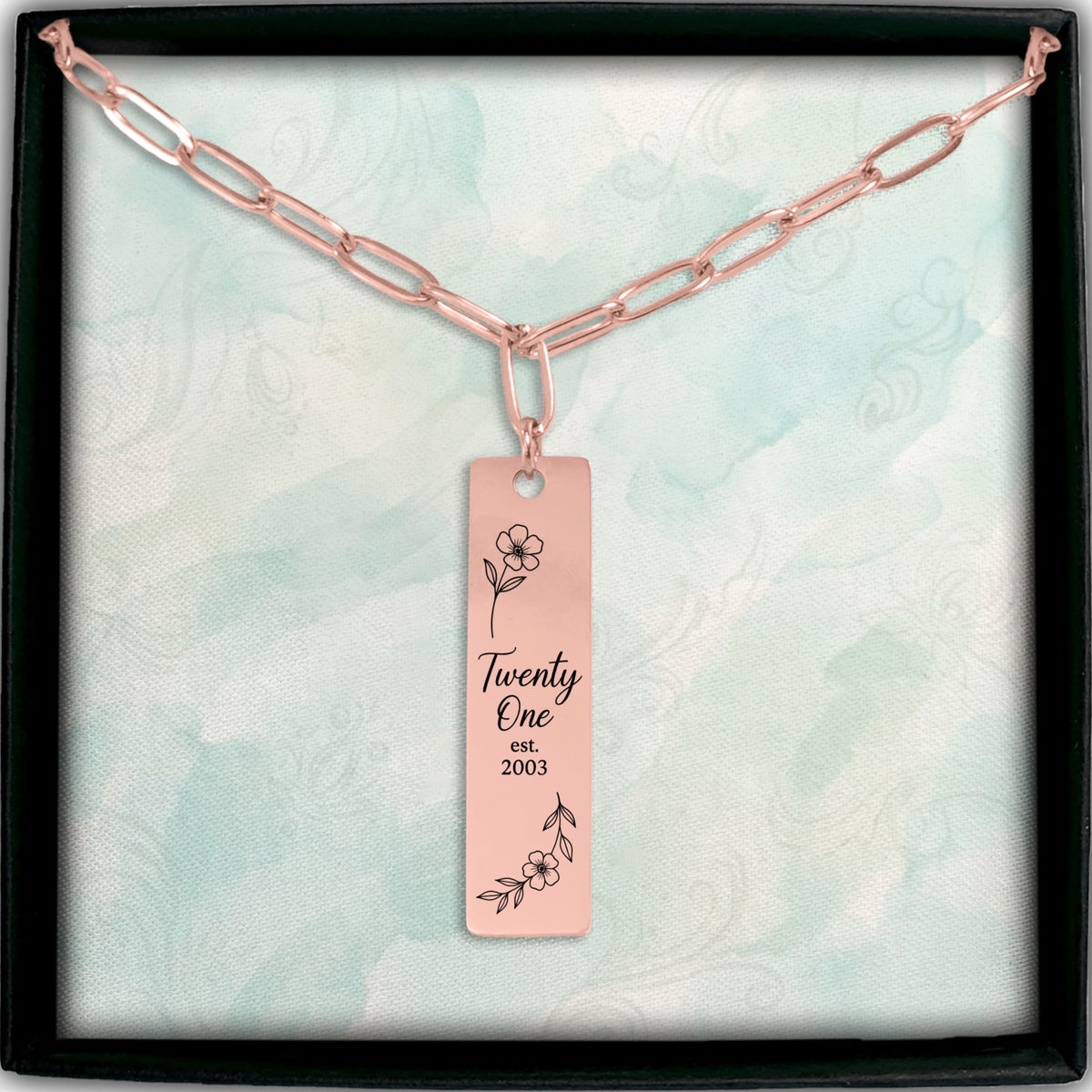 De paperclipketting met gegraveerde staaf in roségoud, in een geschenkdoosje