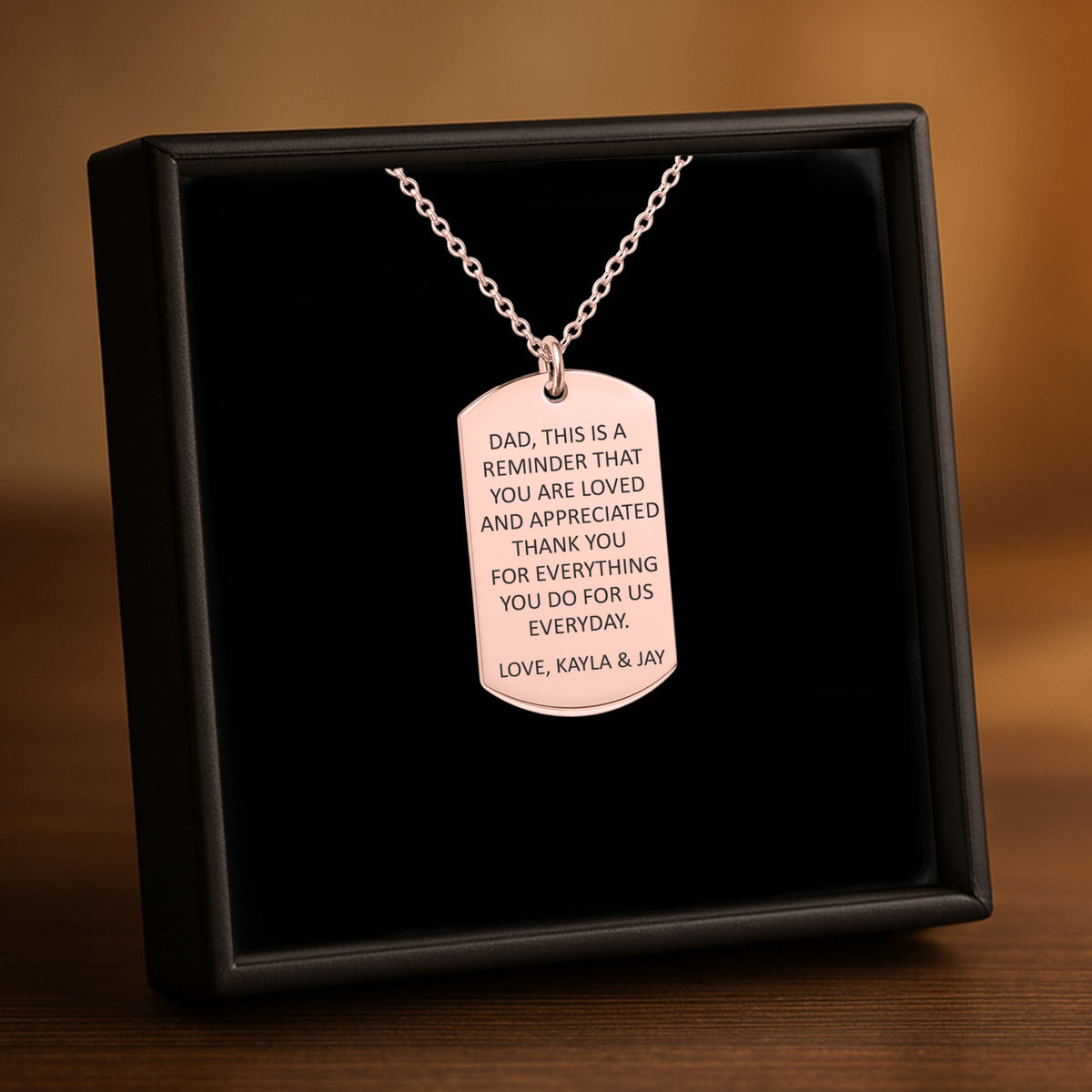De ketting met gegraveerd plaatje in roségoud, in een geschenkdoosje
