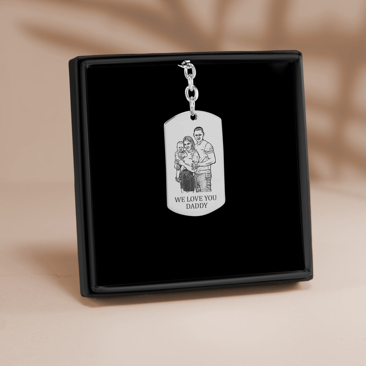 De sleutelhanger met gegraveerd plaatje in zilverkleur, in een geschenkdoosje