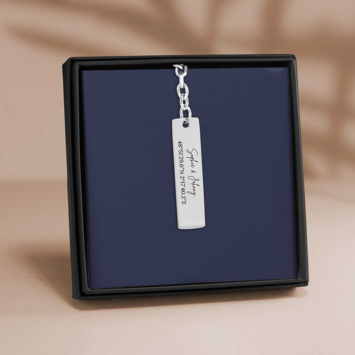 De staafsleutelhanger in zilverkleur, in een geschenkdoosje