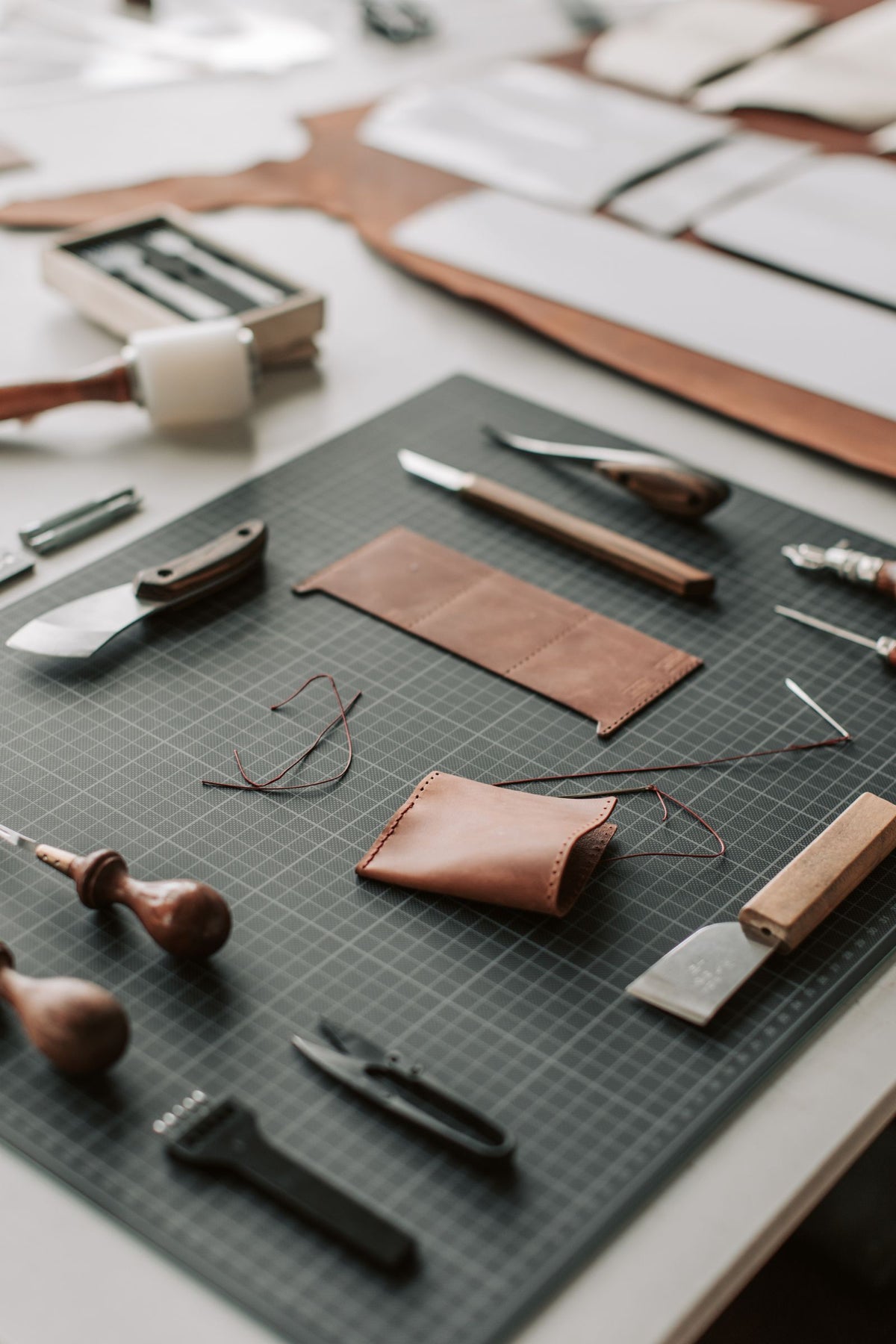 Werkbank met leerbewerkingsgereedschap en stukken leer